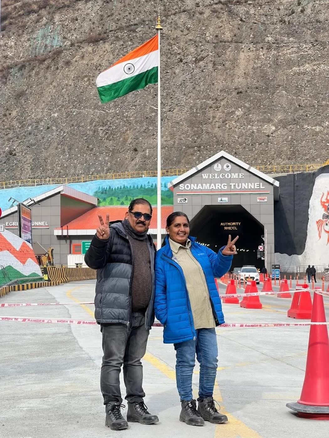 Two travellers at the Sonamarg tunnel under the Indian flag